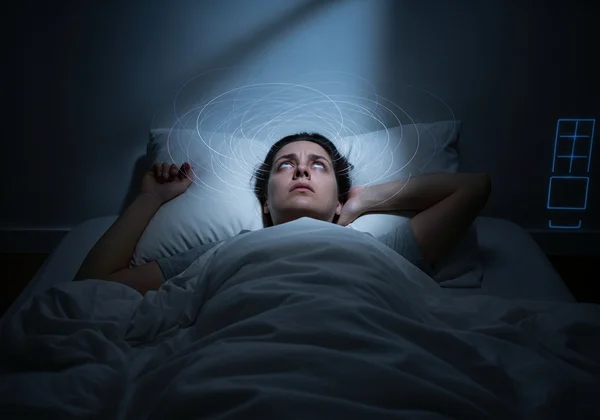 Person tossing and turning, mind racing, struggling to sleep